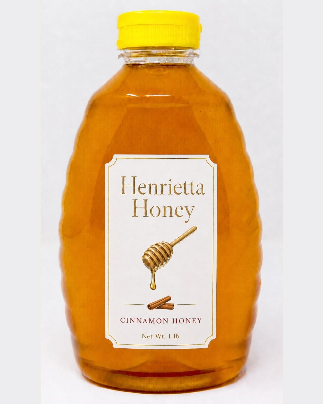 A 1 lb bottle of Henrietta Honey cinnamon infused honey with a gold foil label